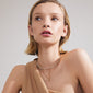 Woman wearing ARLET necklace 2-in-1 set, featuring a gold-plated box chain with heart pendant and pearl necklace, perfect for layering.