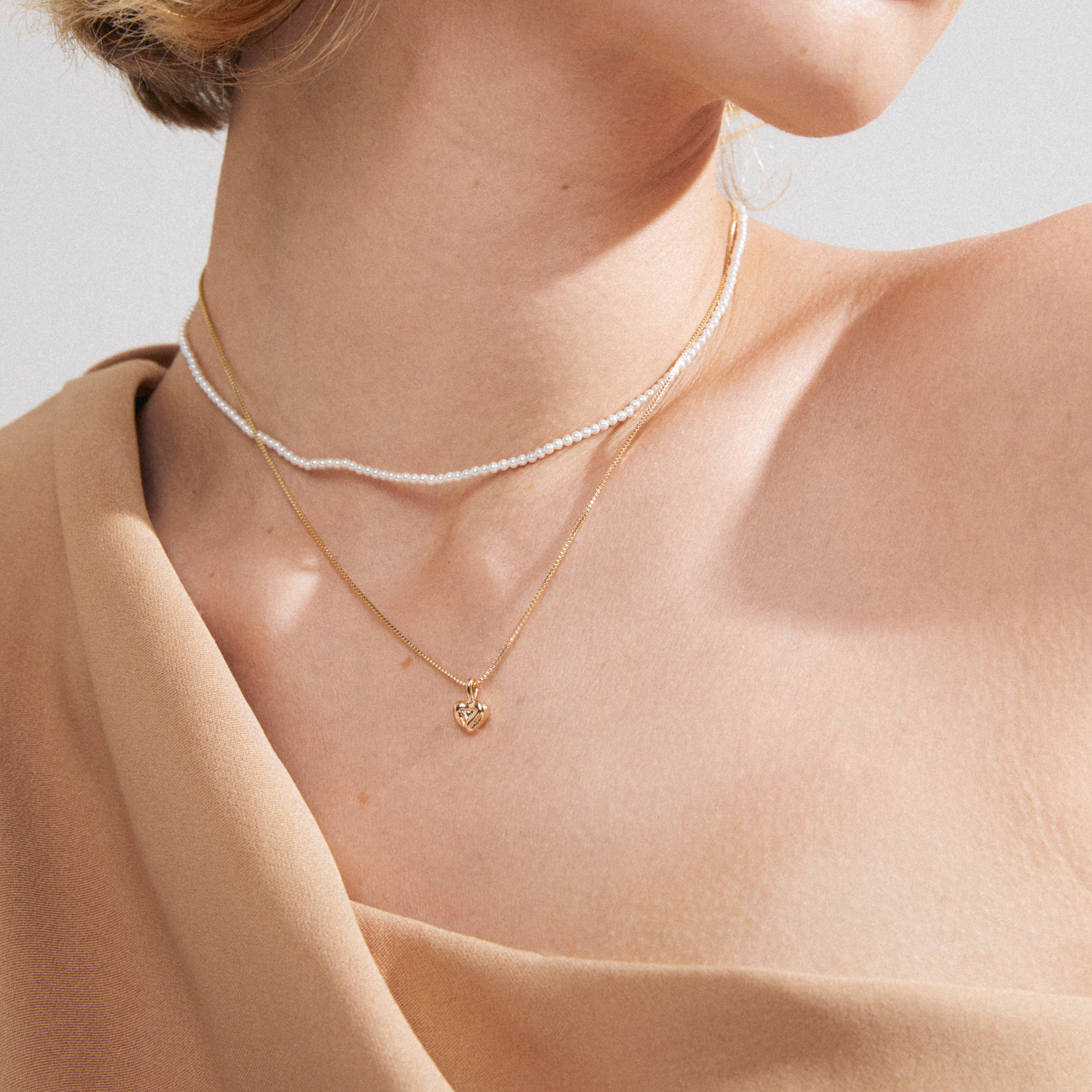 ARLET necklace 2-in-1 set: a layered look with a pearl strand and gold-plated chain featuring a heart pendant, perfect for versatile styling.