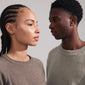 A man and woman wear the ARLET gold-plated heart stud earrings, showcasing the timeless Pilgrim design made from recycled materials.