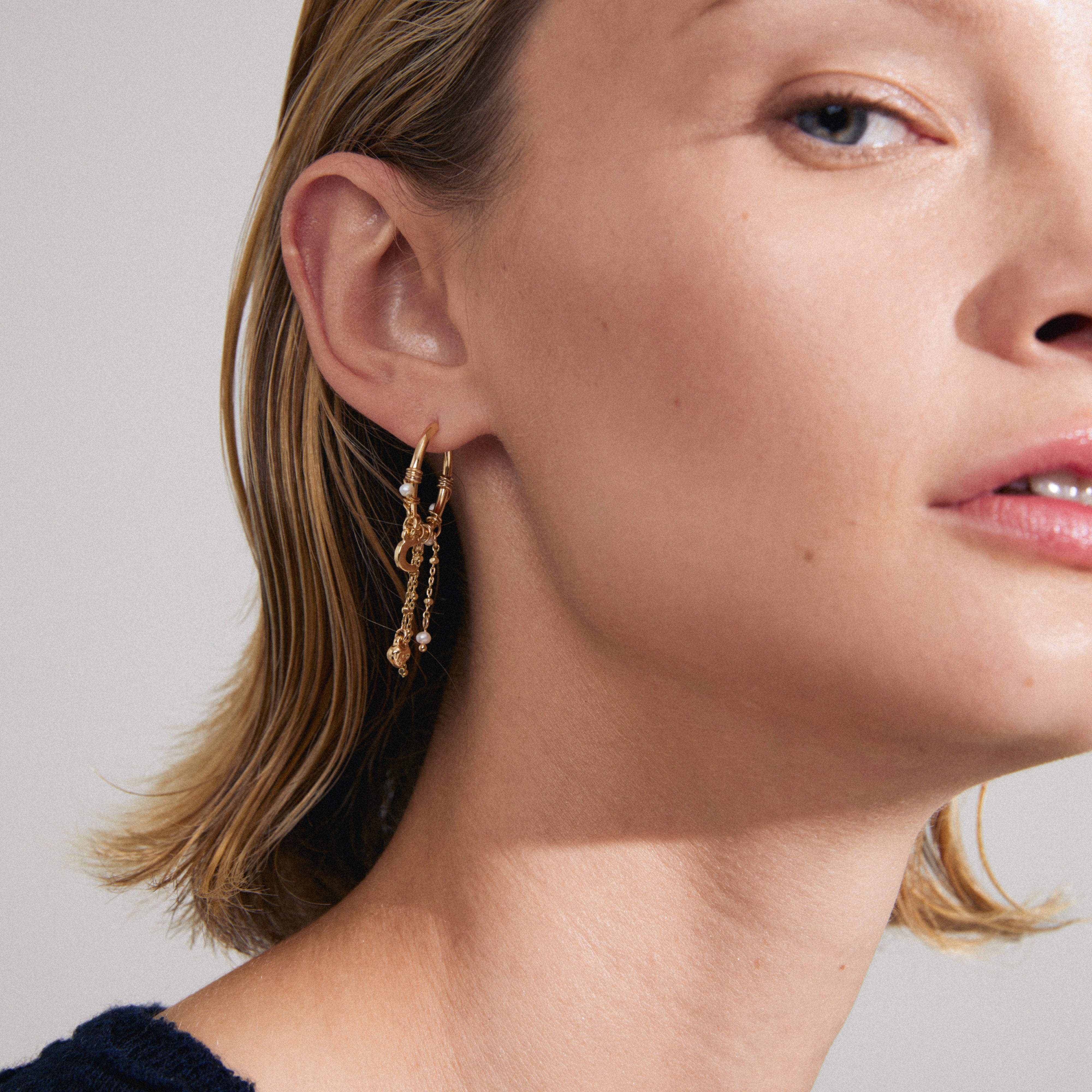ARLET gold-plated earrings featuring a hoop design with freshwater pearls, Preciosa crystals, and moon pendants, offering a romantic boho-lux vibe.