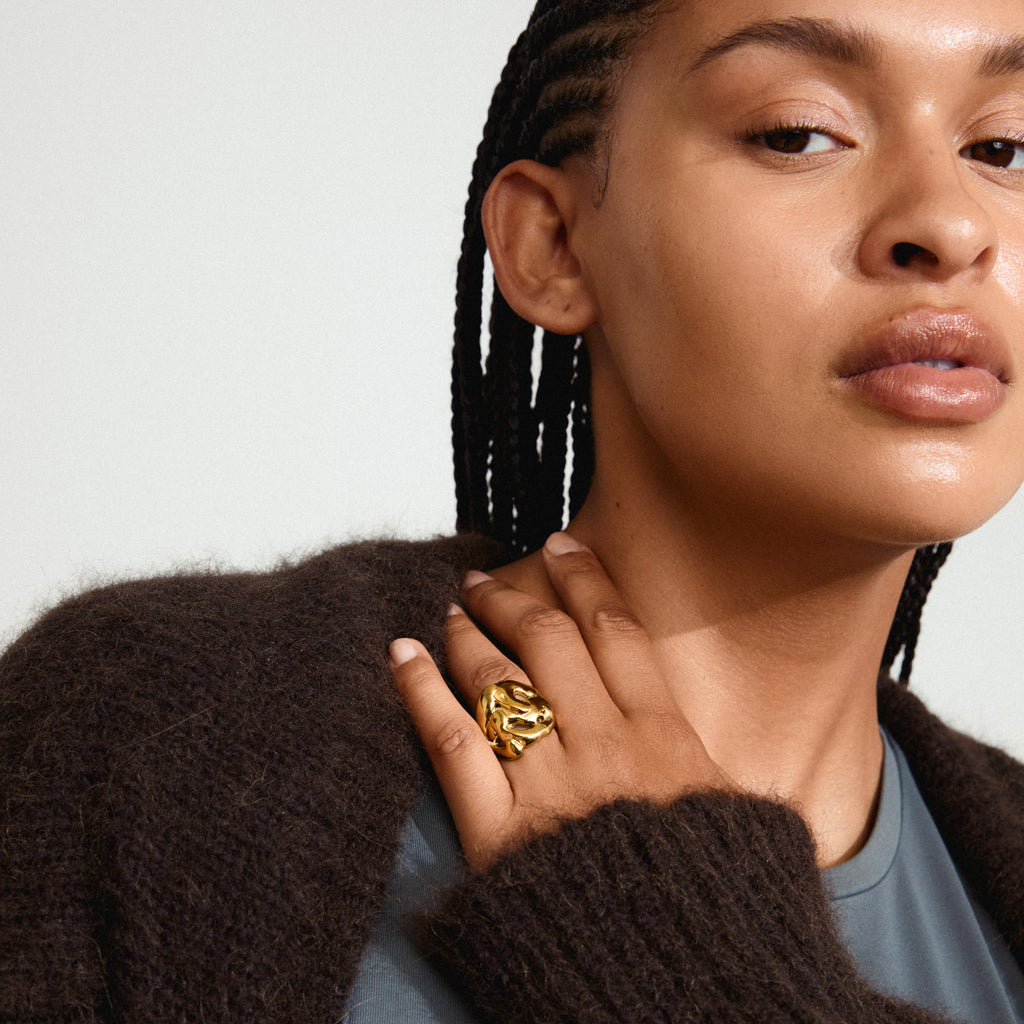 Close-up of a woman wearing the LUCA ring gold-plated by Pilgrim, showcasing its unique, handcrafted bohemian design with organic shapes and an adjustable fit.