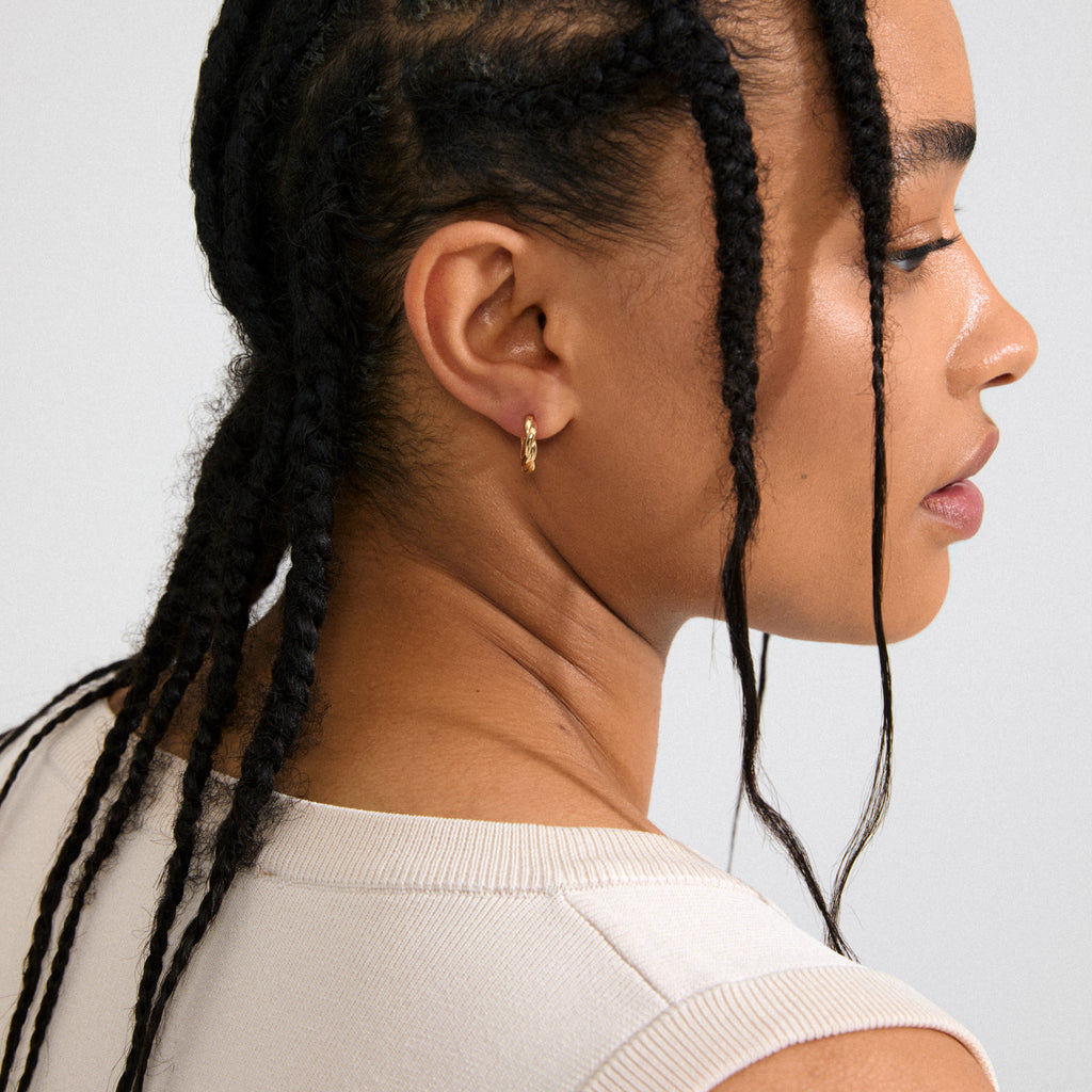 DECLAN gold-plated hoops with twisted design and click clasps, crafted from 99% recycled materials, offering timeless style for any outfit.