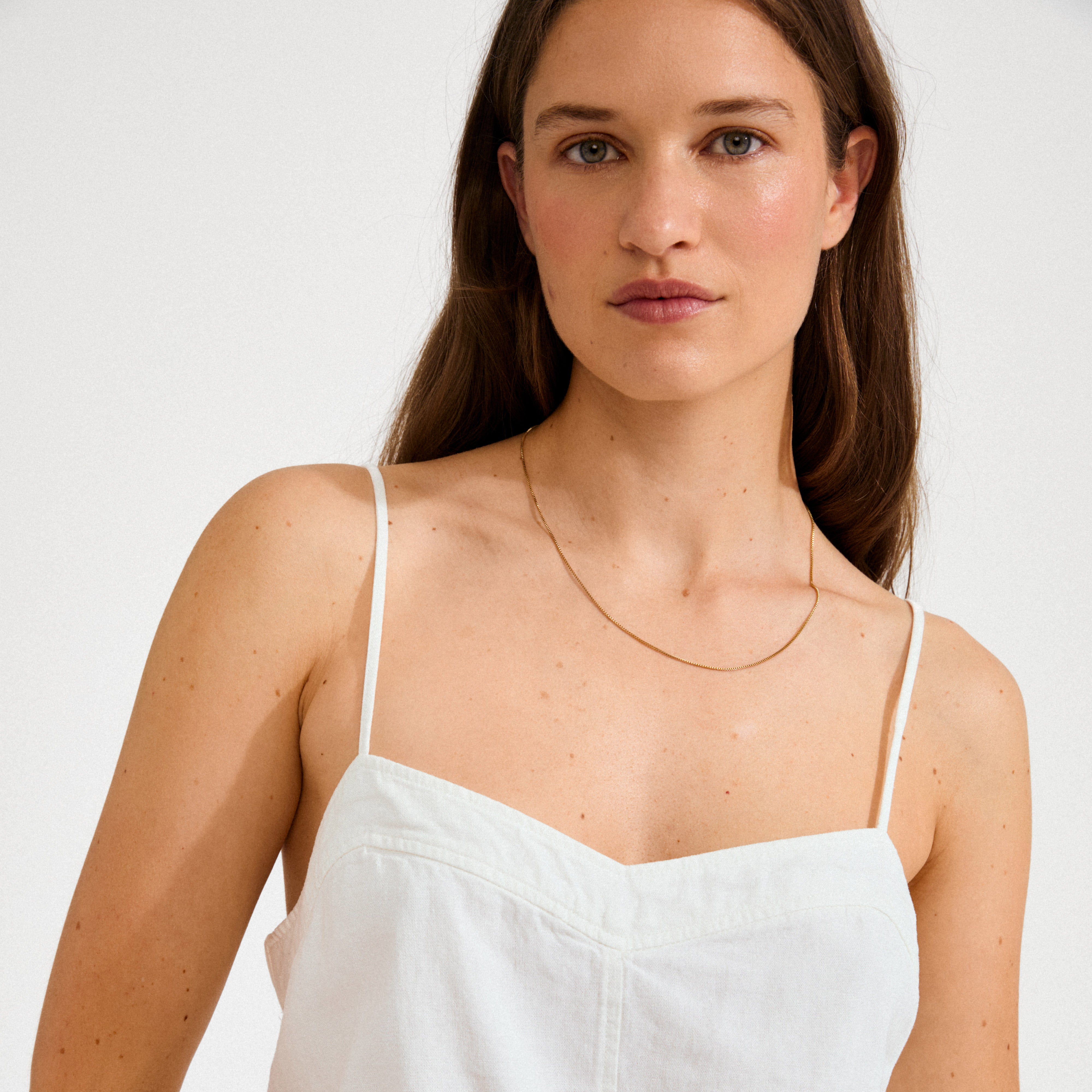 NANCY necklace 50 cm gold-plated on a woman with a white top, showcasing its versatile elegance ideal for minimalist or layered styles.