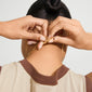 Person fastening the NANCY necklace 50 cm gold-plated, highlighting its simplicity and versatility, ideal for layering or pairing with a pendant.