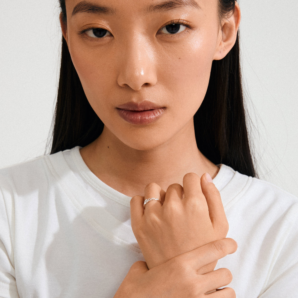 Close-up of a woman wearing the silver-plated Lulu mom stack ring, highlighting its simple, elegant design, a tribute to love and family.