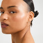 Close-up of a person wearing LEANNA good luck crystal earrings gold-plated, featuring sparkling crystals on a polished horseshoe design, symbolizing good luck.