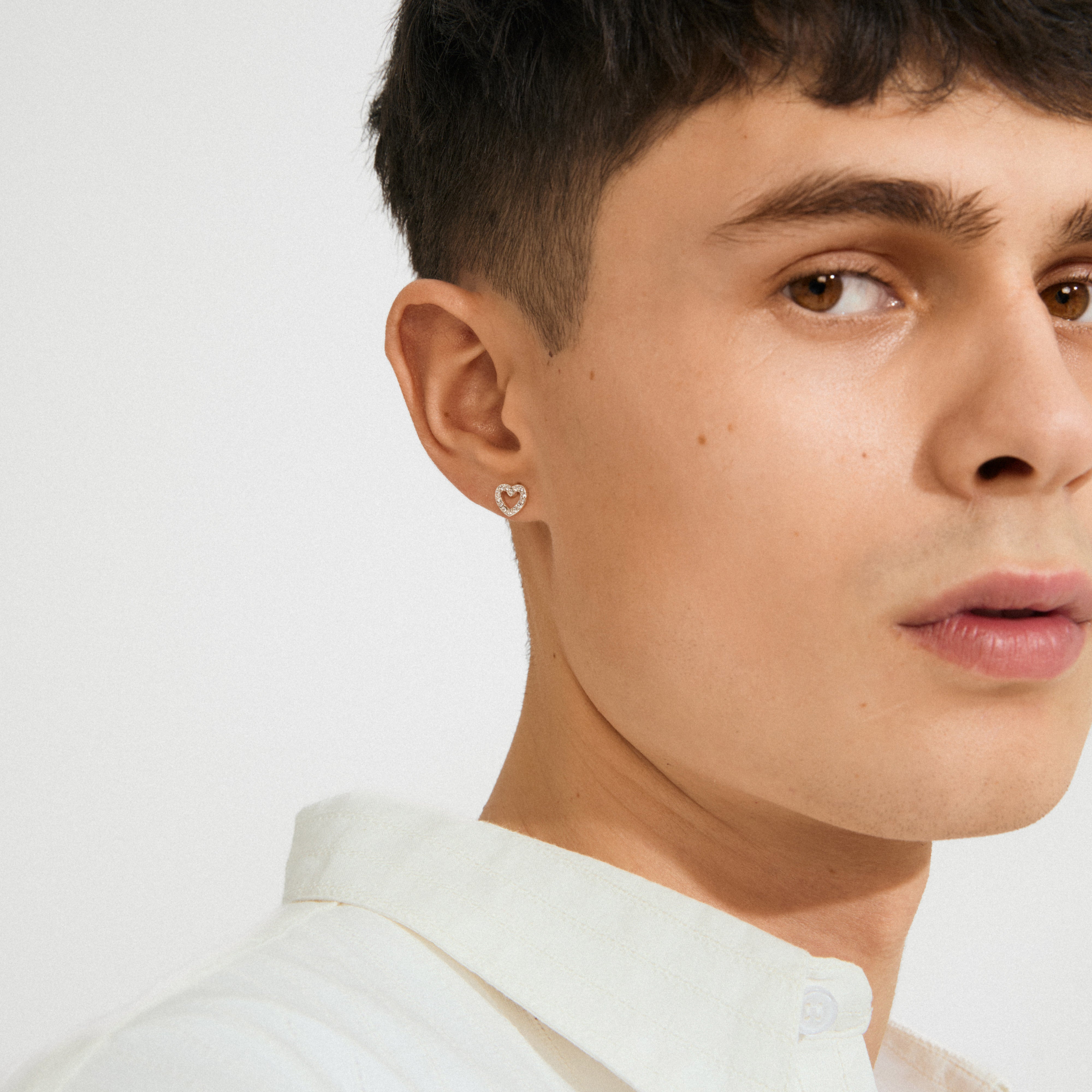 Close-up of a young person wearing EDIE crystal heart earrings, silver-plated with sparkling stones, highlighting their delicate and romantic design.