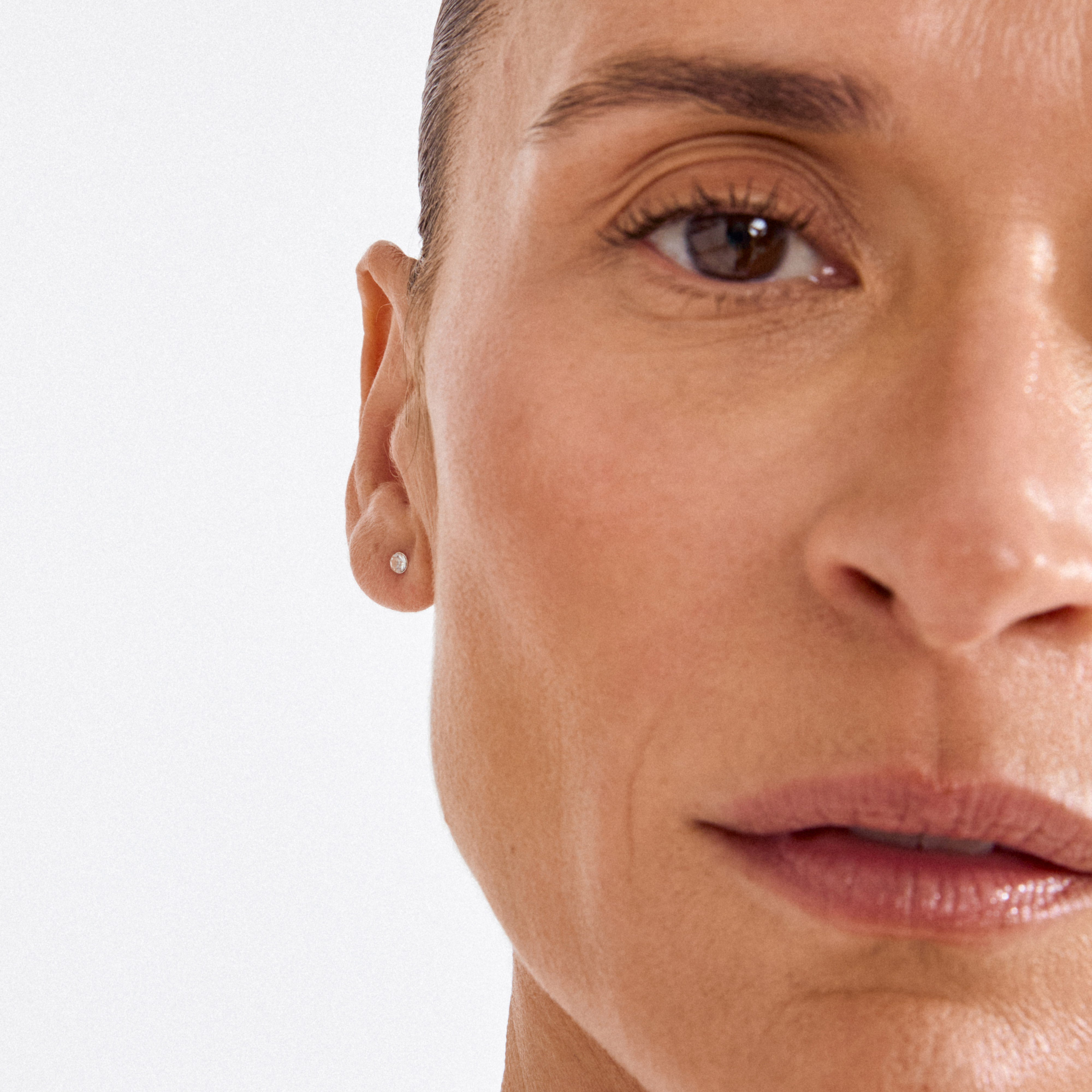 SYLVIE small crystal stud earrings in silver-plated setting, subtly enhancing the ear with a minimalist sparkle, perfect for stacking or a solo elegant touch.