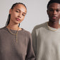 AMIRI gold-plated necklace with flowing cable chain and Preciosa crystals, worn by a man and woman, showcasing timeless elegance and modern design.
