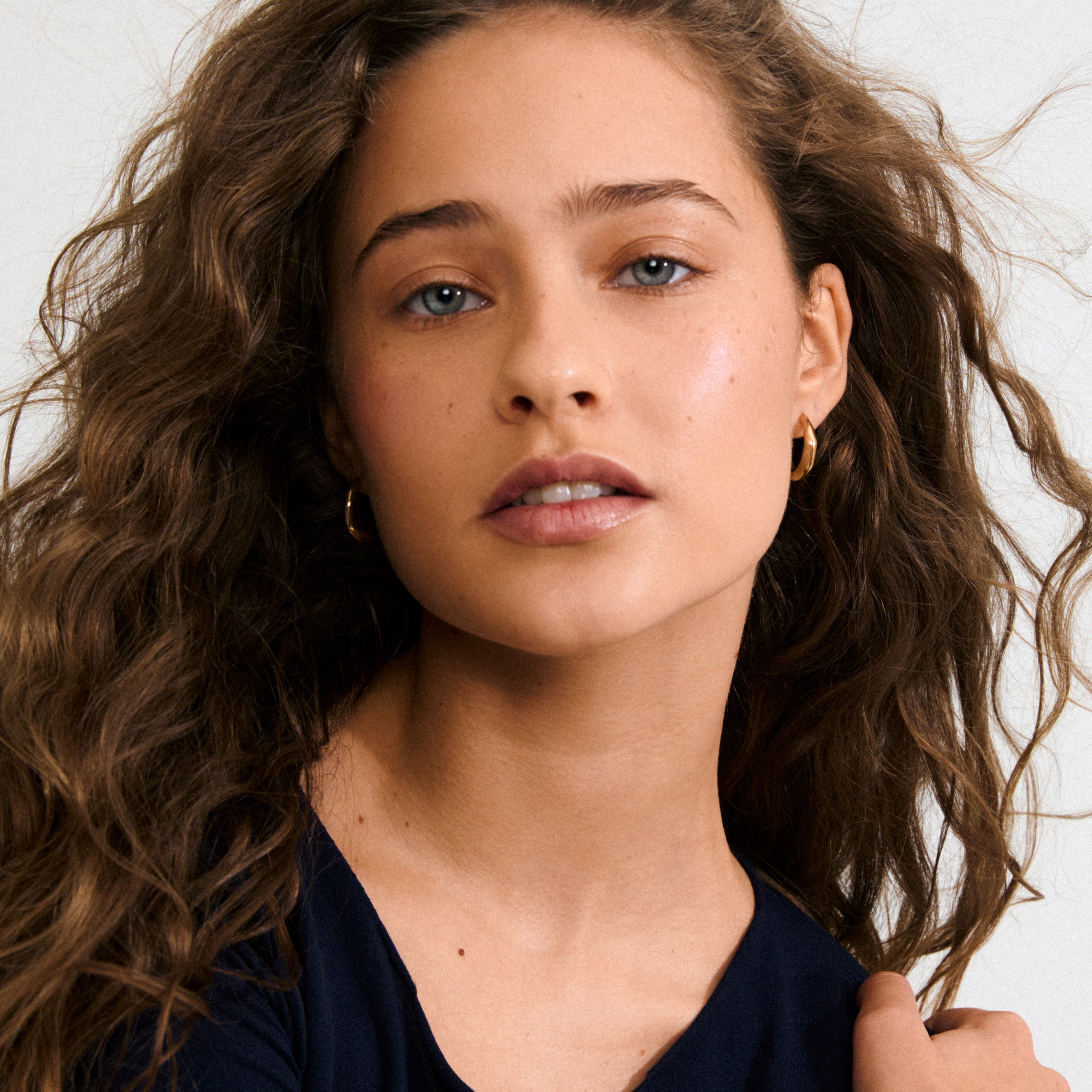 HARRISON hoops gold-plated earrings with a sleek, wavy Scandinavian design, featuring easy snap locks. Made from 99% recycled materials. Perfect for everyday effortless style.