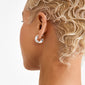 JENNINGS silver-plated hoop earrings, chunky and polished, seen on a person with bleached-blonde hair, embodying Pilgrim's trendy, elegant Danish craftsmanship with a subtle statement.