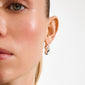 Close-up of a person wearing the JENNINGS silver-plated earrings, showcasing their unique double droplet design, wrapping around the ear for a sculptural effect.