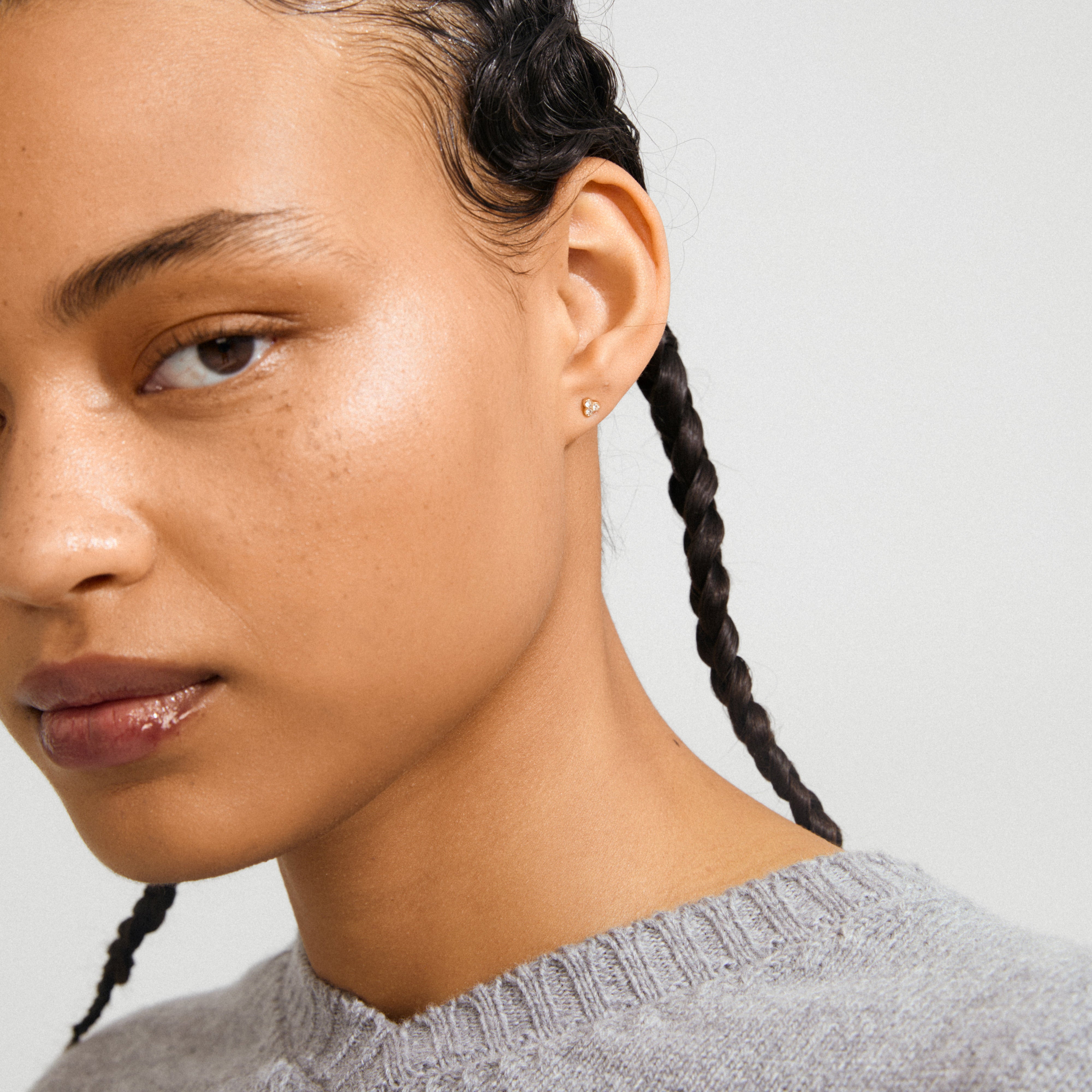 Profile of a young person wearing CAILY crystal earrings gold-plated, featuring three clear crystals in a bouquet design, highlighting elegance and subtle sophistication.
