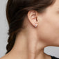 BRIGITTE crystal half hoops silver-plated adorn a woman's ear, showcasing sparkling round crystals on fine, undulating edges, reflecting light elegantly for a luxe aesthetic.