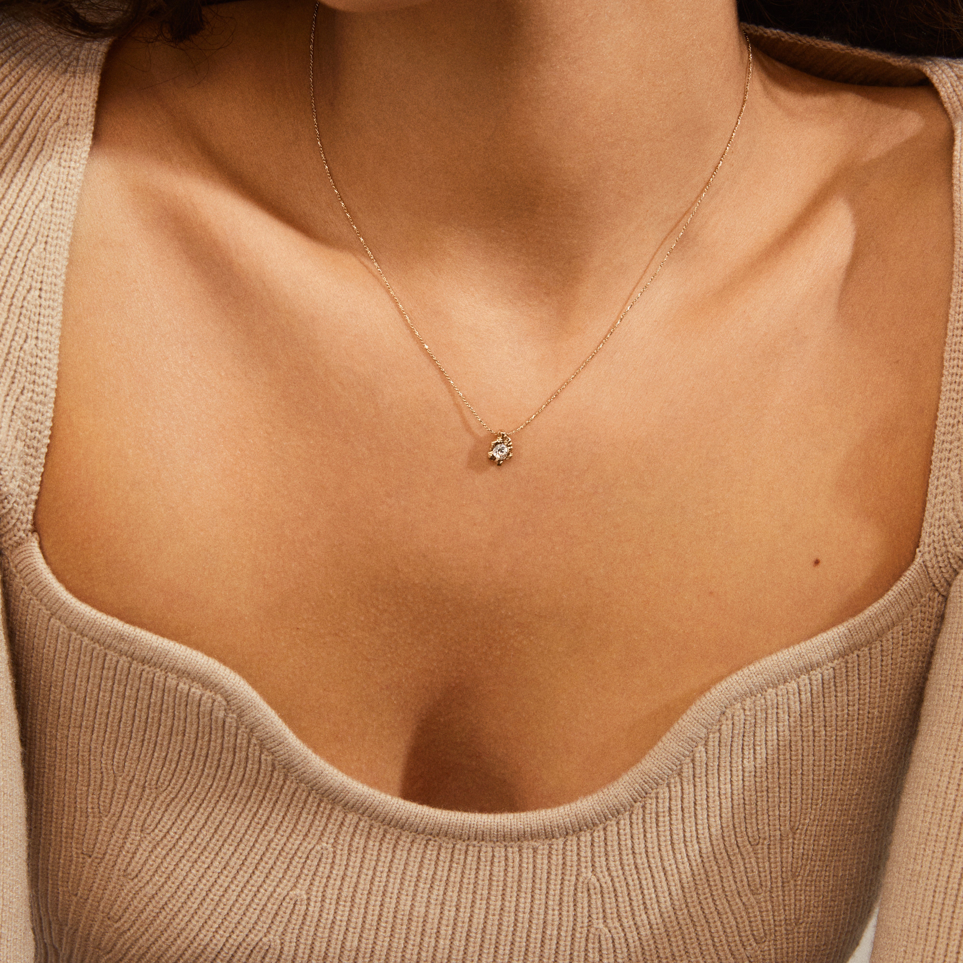TINA crystal pendant necklace gold-plated, featuring a delicate recycled gold chain with an asymmetrical pendant and Preciosa crystal, worn above the collarbone.