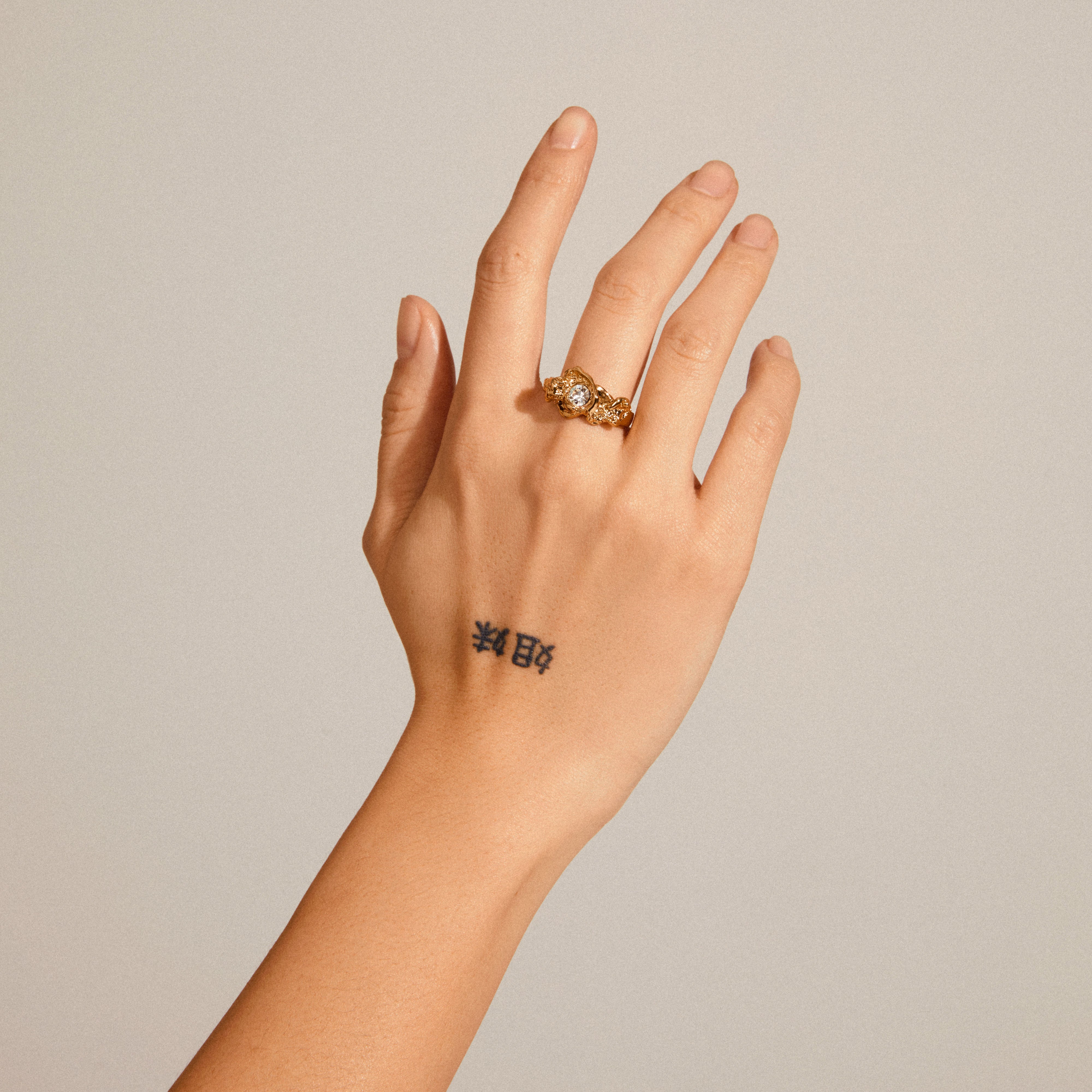 TINA organic shape crystal ring gold-plated on a hand, showcasing its nature-inspired design and central large crystal. Part of Pilgrim's recycled collection.