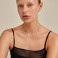 RIKO necklaces, 2-in-1 silver-plated set, featuring a slim curb chain and nature-inspired flower pendants, worn by a woman in a black tank top.