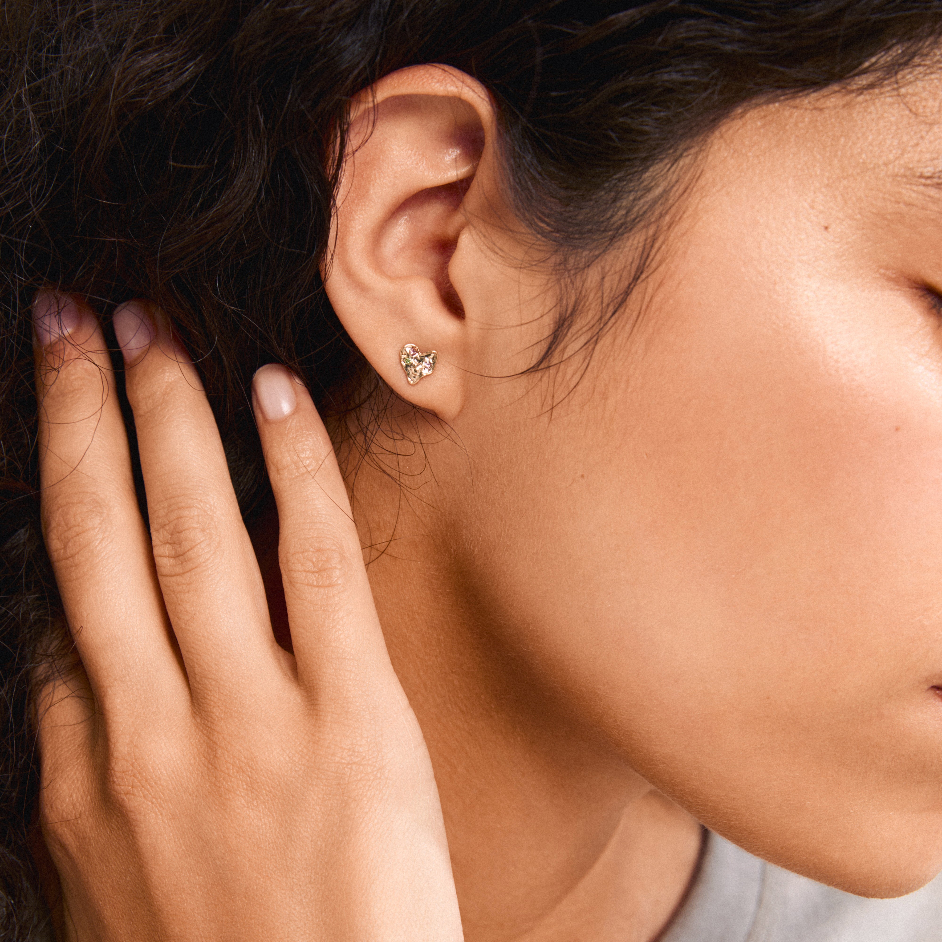 Close-up of a woman's ear wearing the gold-plated RYAN heart earrings by Pilgrim, showcasing their elegant, handcrafted, and romantic design.