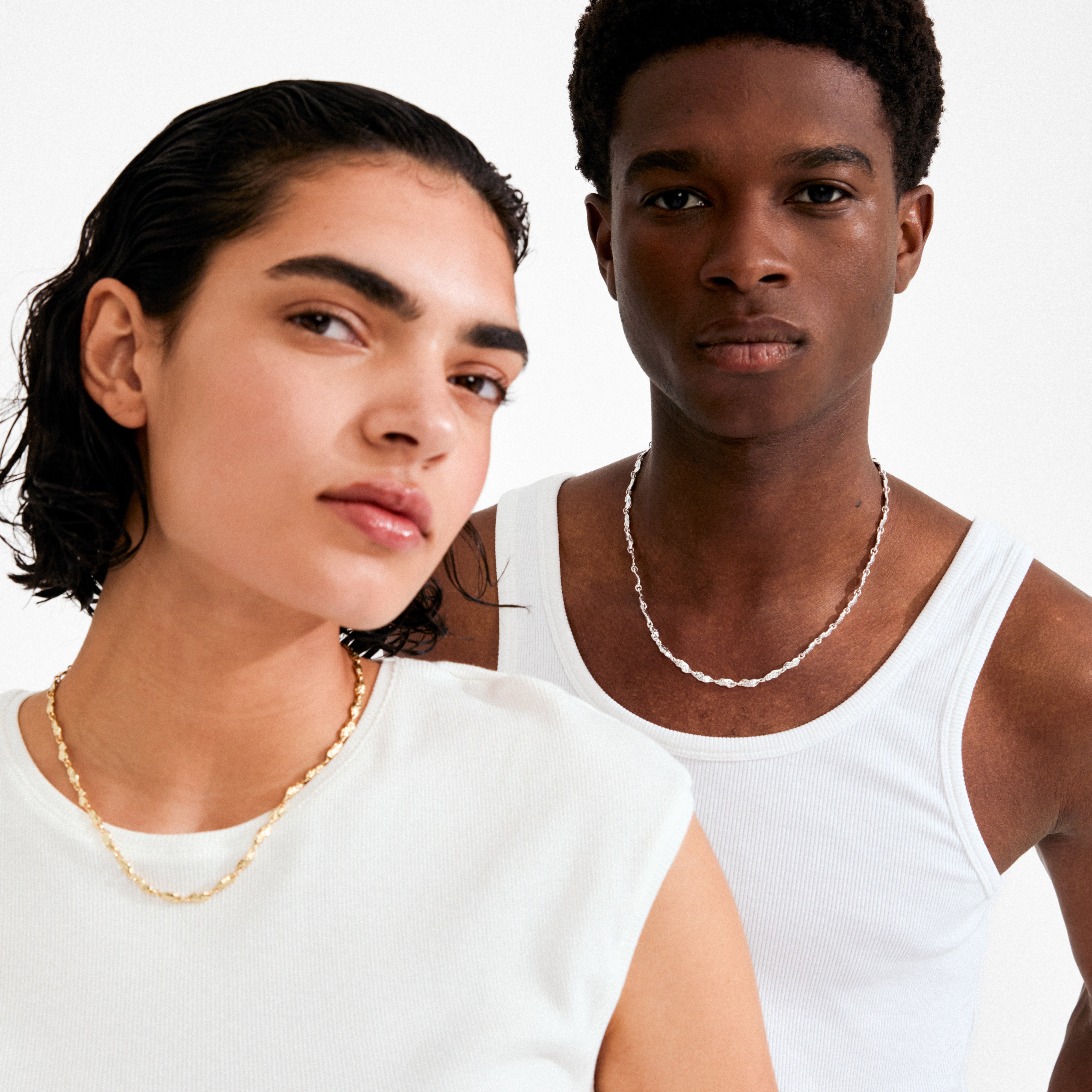Two people wear Pilgrim's ELIYAH necklace; one gold-plated on the left, one silver-toned on the right, both capturing an effortlessly cool, refined vibe.