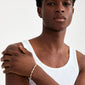 Young man wearing Pilgrim's ELIYAH gold-plated bracelet with textured links, showcasing rustic elegance and timeless style against a minimalistic backdrop.