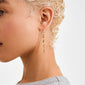 Side profile highlighting ELIYAH chain earrings gold-plated, featuring textured nugget-shaped links, exuding sculptural elegance and movement, worn by a person with bleached-blonde hair.