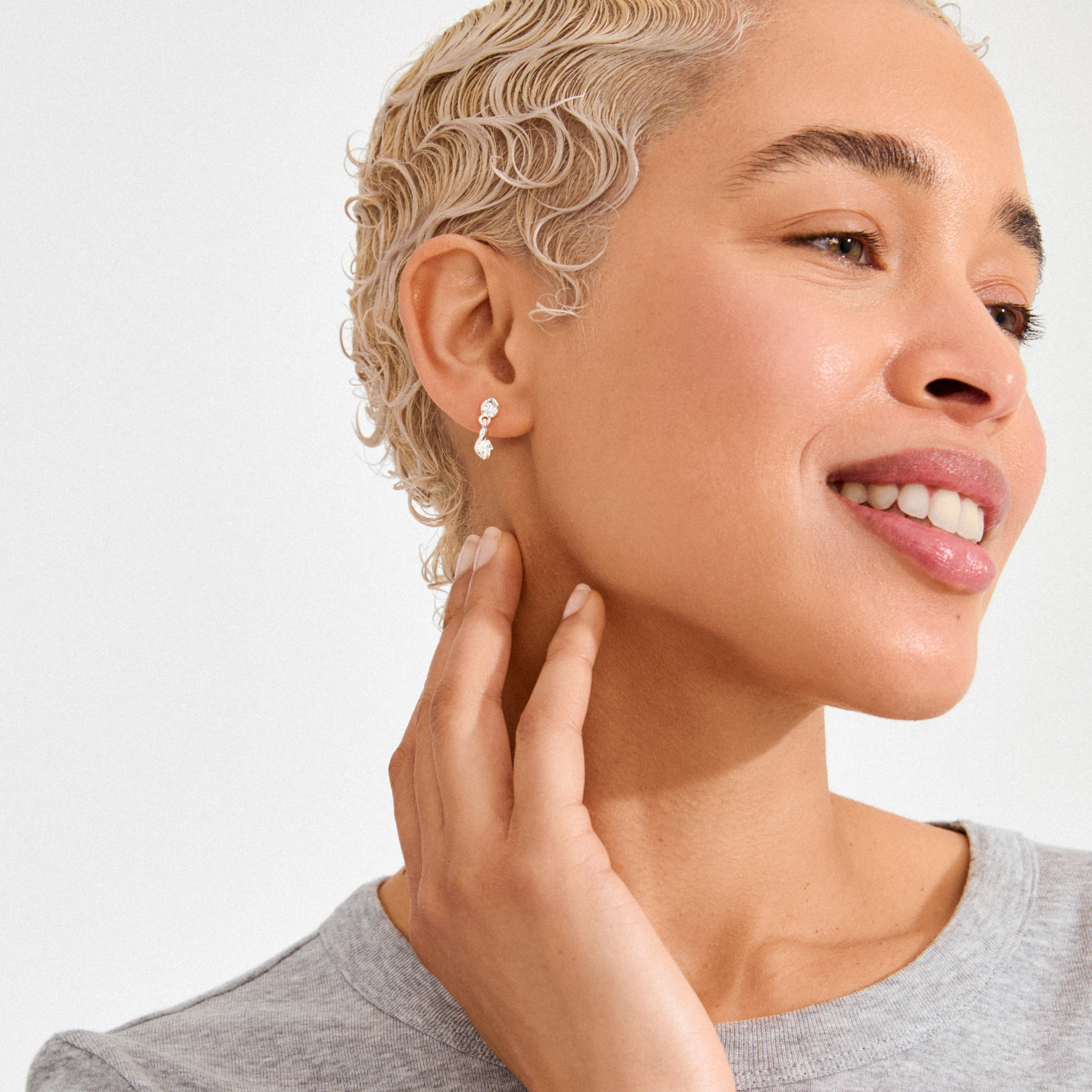 Profile of a woman wearing ELIYAH earrings, silver-plated with clear drop stones, showcasing their wavy, sculptural design and effortless elegance.