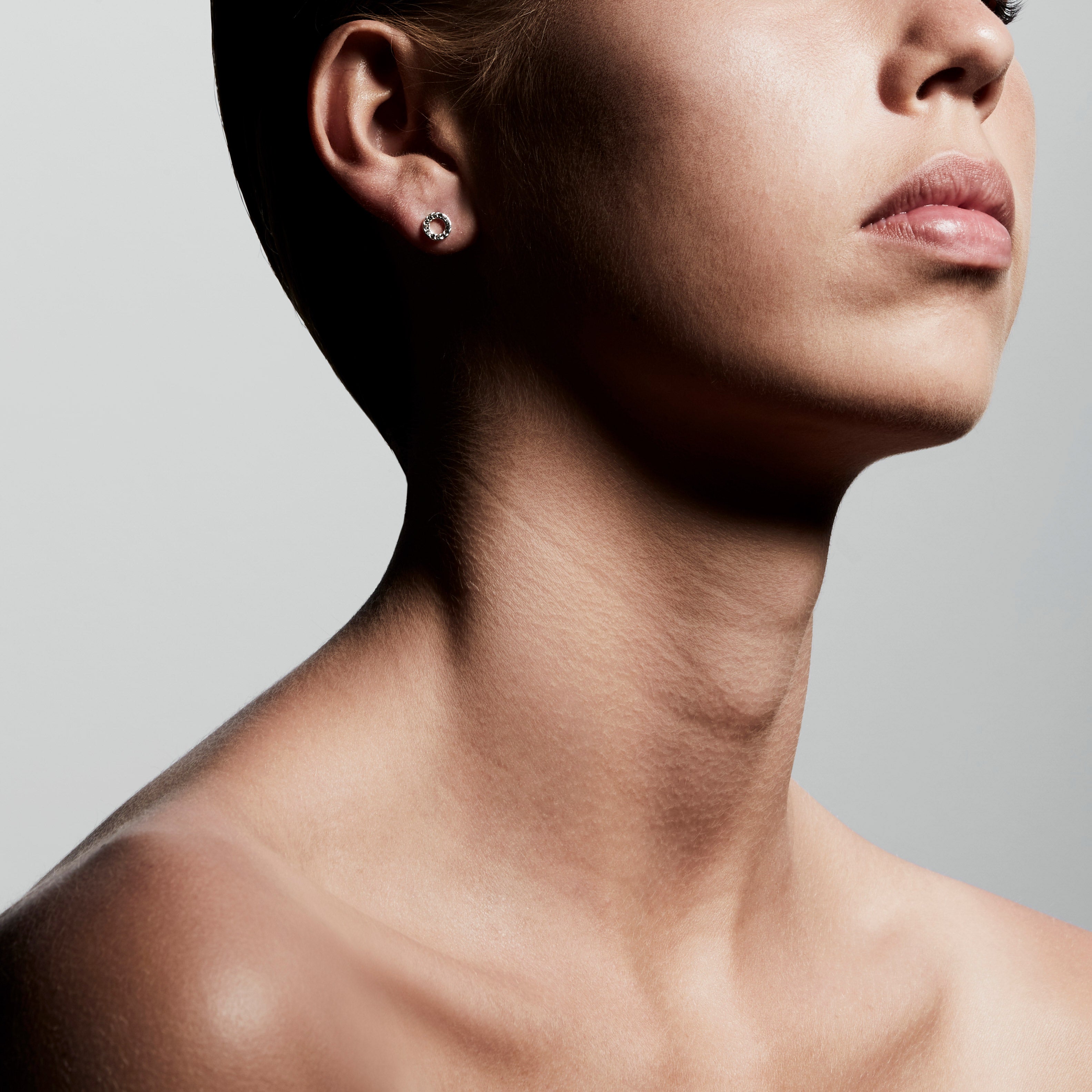 TESSA crystal halo earrings silver-plated, worn by a woman with a short haircut, showcasing their classic, delicate design adorned with Preciosa crystals.