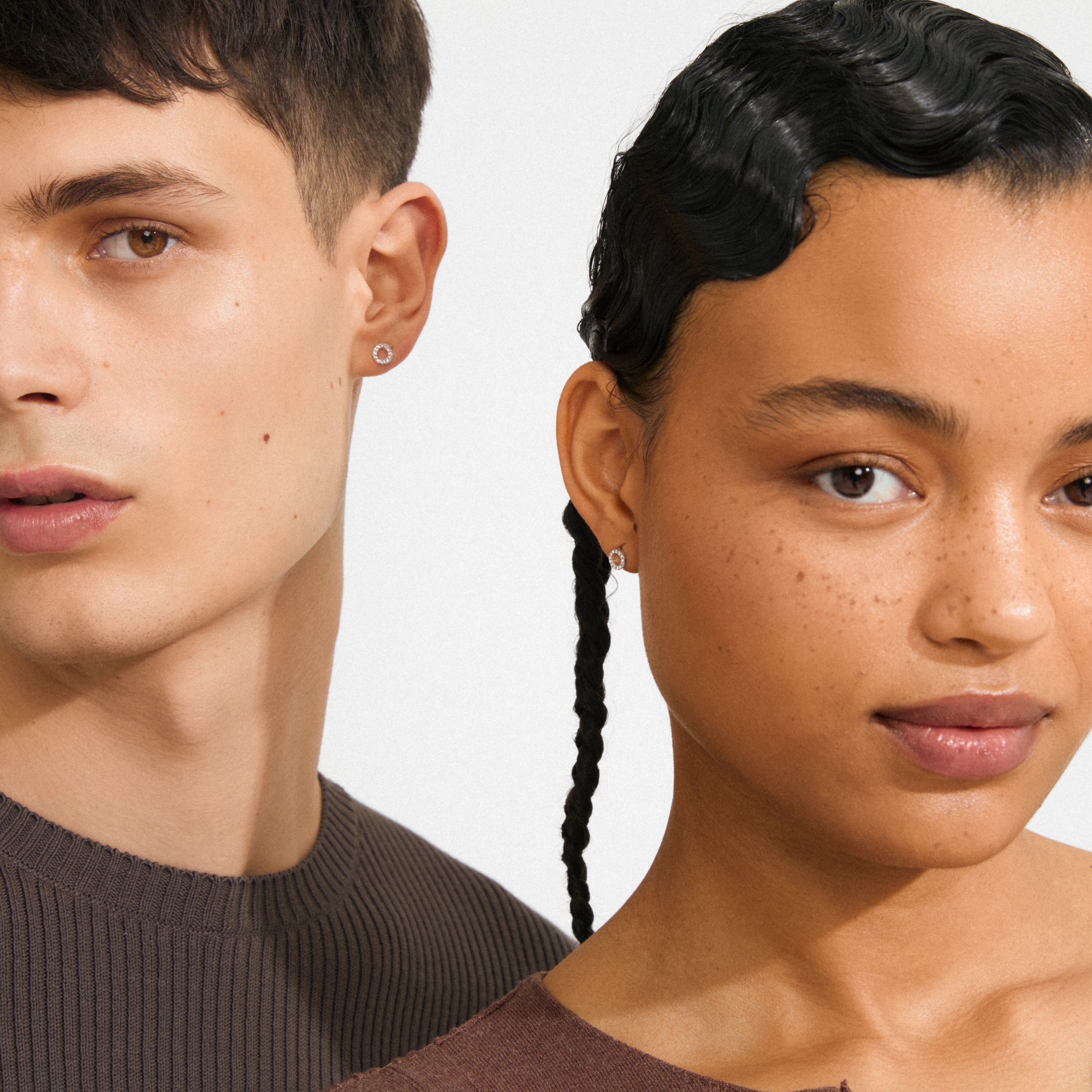 TESSA crystal halo earrings silver-plated adorn a young man and woman, showcasing their delicate, studded elegance against a soft backdrop, embodying Pilgrim's timeless, inclusive style.