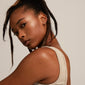 TYRA chunky mini hoop earrings gold-plated, worn by a woman with long hair, showcasing their simple, classic design from Pilgrim's recycled collection.
