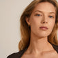 TYRA chunky hoop earrings gold-plated by Pilgrim, highlighting a woman wearing the timeless, classy hoops with a strong, shiny surface, embodying Scandinavian quality and style.