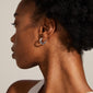 TYRA chunky hoop earrings, silver-plated, showcased on a woman's ear. These classic hoops from Pilgrim are stylish and eco-friendly, made from 99% recycled materials.