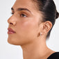 Profile showcasing the TYRA chunky hoop earrings in silver-plated finish, highlighting their polished, sleek design on a young adult with a bun hairstyle.