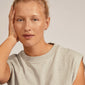 Close-up of a woman wearing EDDY organic shaped mini huggie hoops, gold-plated, showcasing their undulating, handcrafted surface inspired by nature.