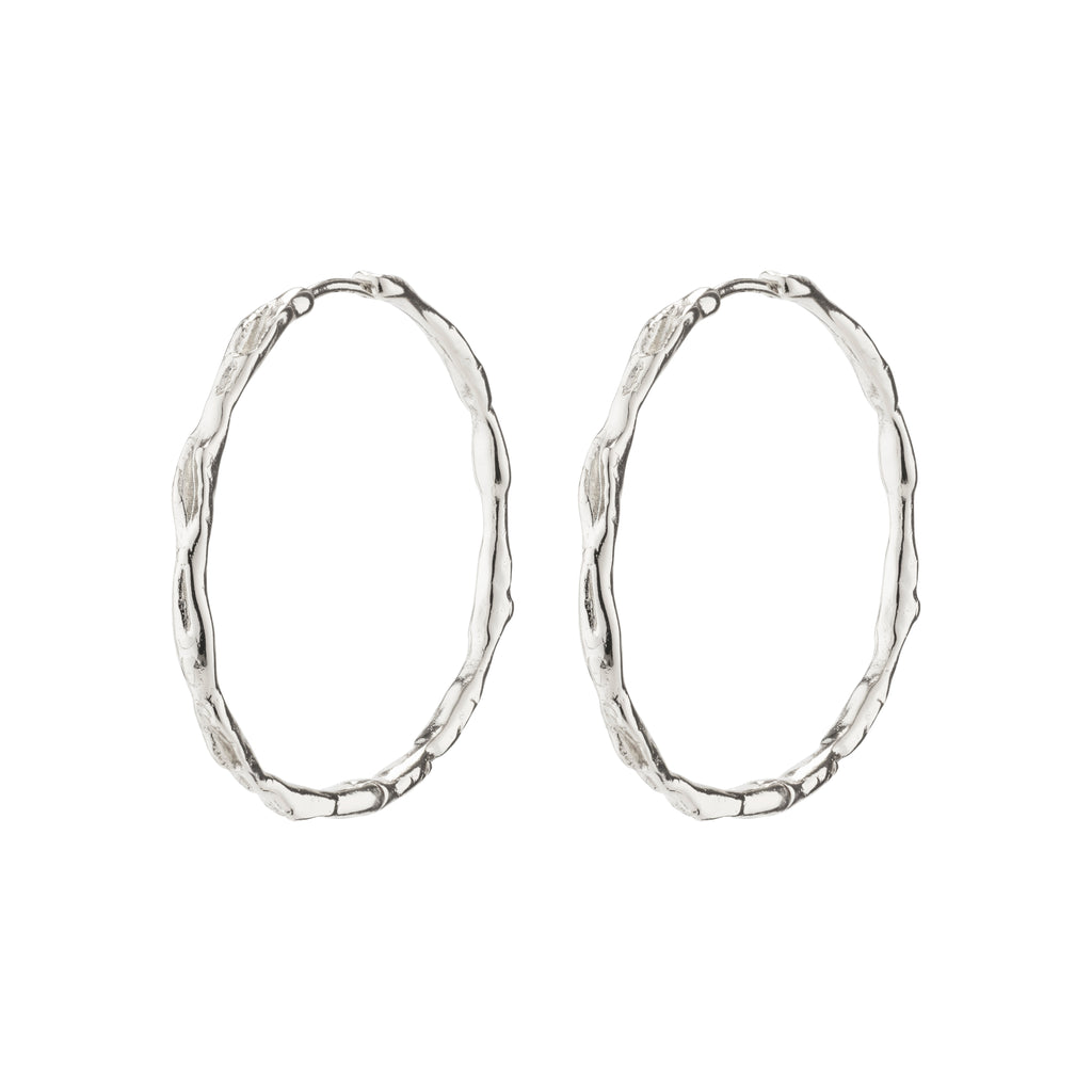 EDDY organic shaped maxi hoops, silver-plated with a wavy surface, showcasing Pilgrim's handcrafted, Scandinavian style. Perfect for enhancing any outfit or adventure.