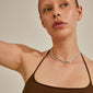 Woman wearing REIGN necklaces, 2-in-1 silver-plated set with layered sparkling blue and champagne crystals, showcasing adjustable lengths for versatile styling.