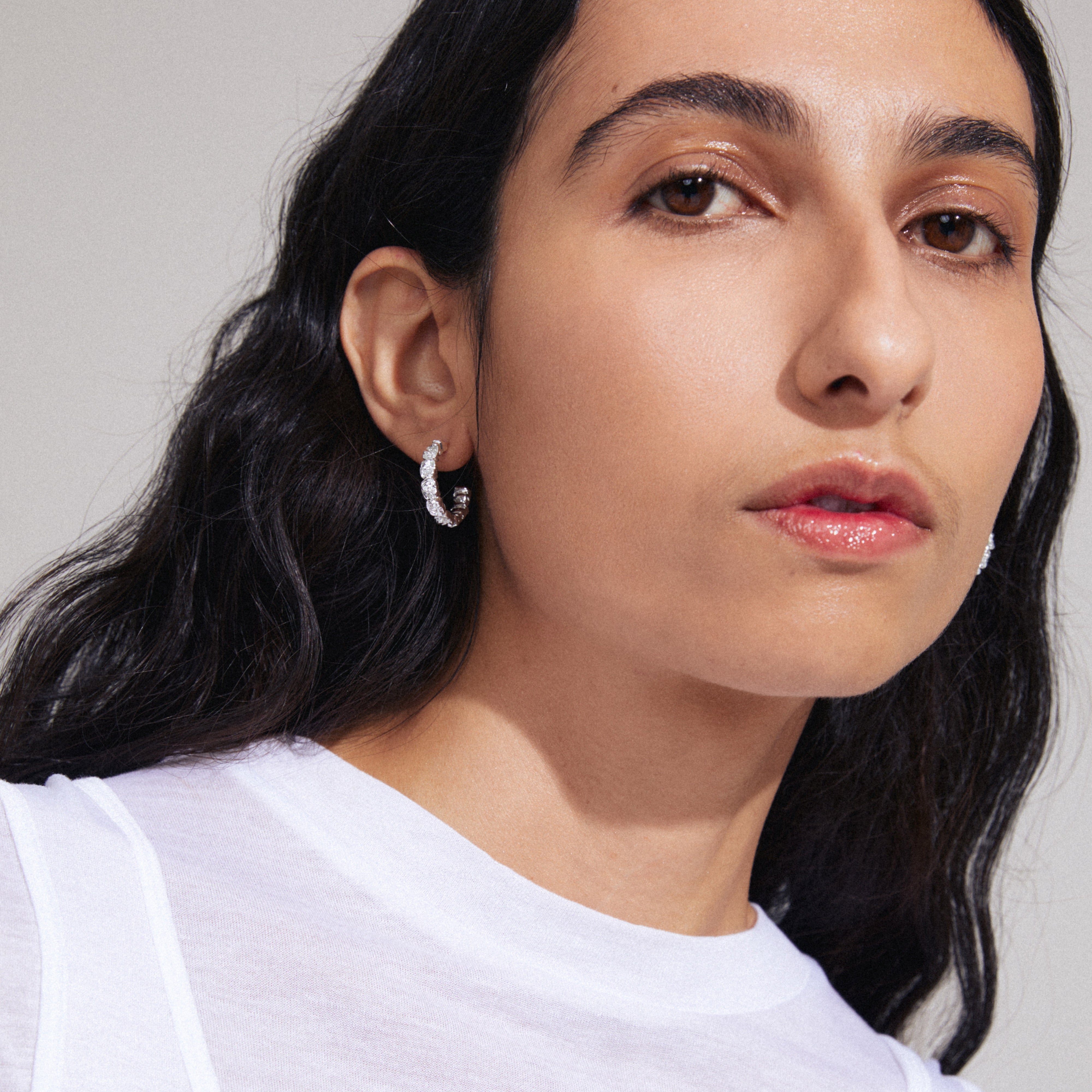 Close-up of a woman wearing Pilgrim's SCOTTIE silver-plated earrings, featuring rustic cubes for a unique, handcrafted look.