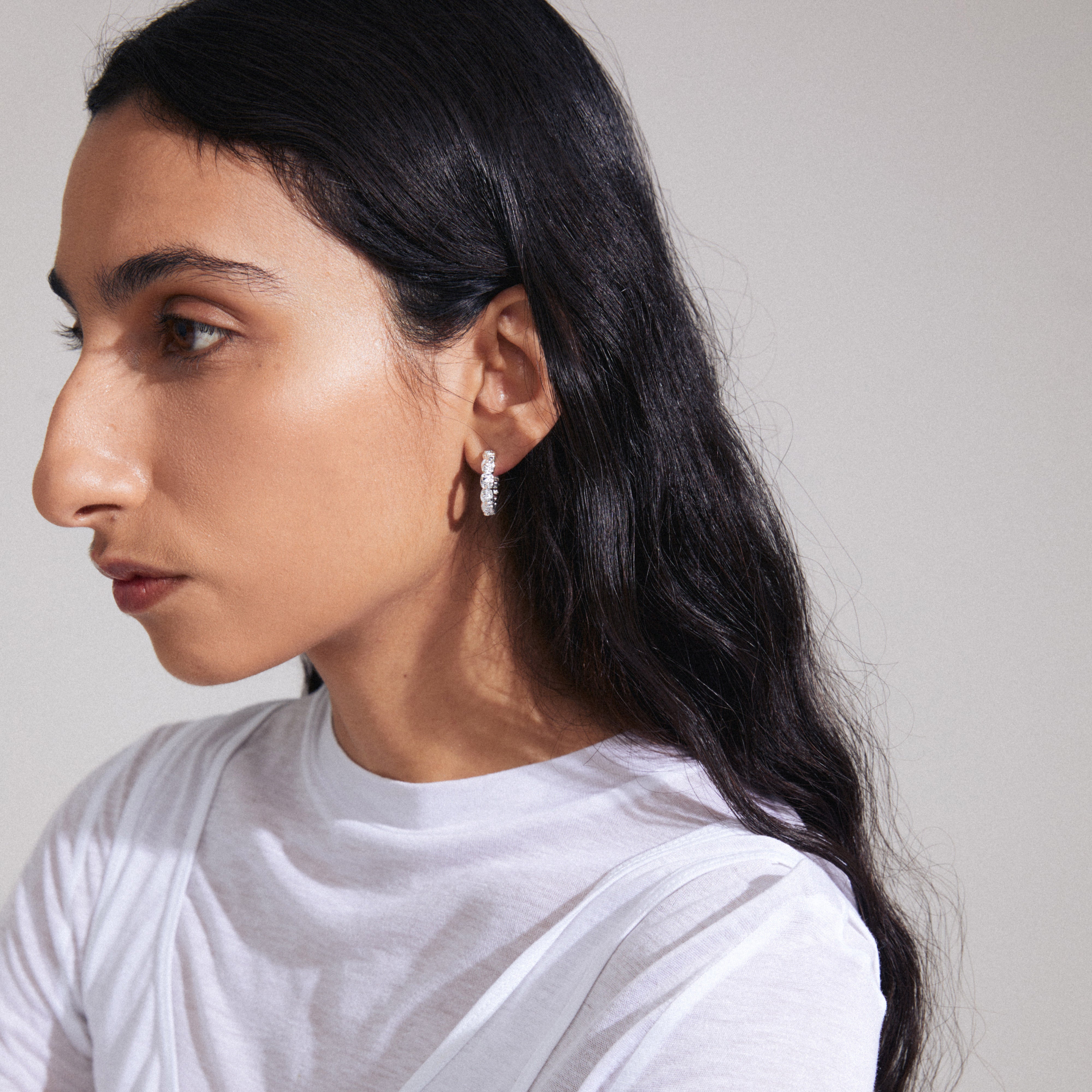 Woman wearing Pilgrim's SCOTTIE silver-plated semi-hoops, featuring rustic cube design, reflecting a handcrafted, unique style.