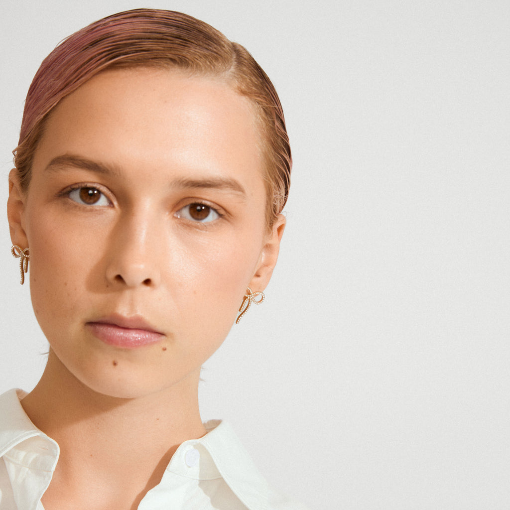 JOLANTA earrings gold-plated: Delicate bow-shaped earrings adorned with Preciosa crystals, perfect for elevating everyday outfits or adding sparkle to formal looks.