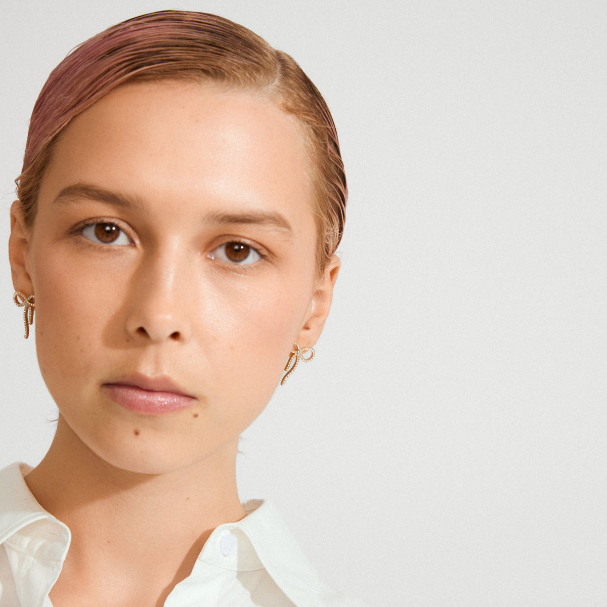 JOLANTA earrings gold-plated: Delicate bow-shaped earrings adorned with Preciosa crystals, perfect for elevating everyday outfits or adding sparkle to formal looks.