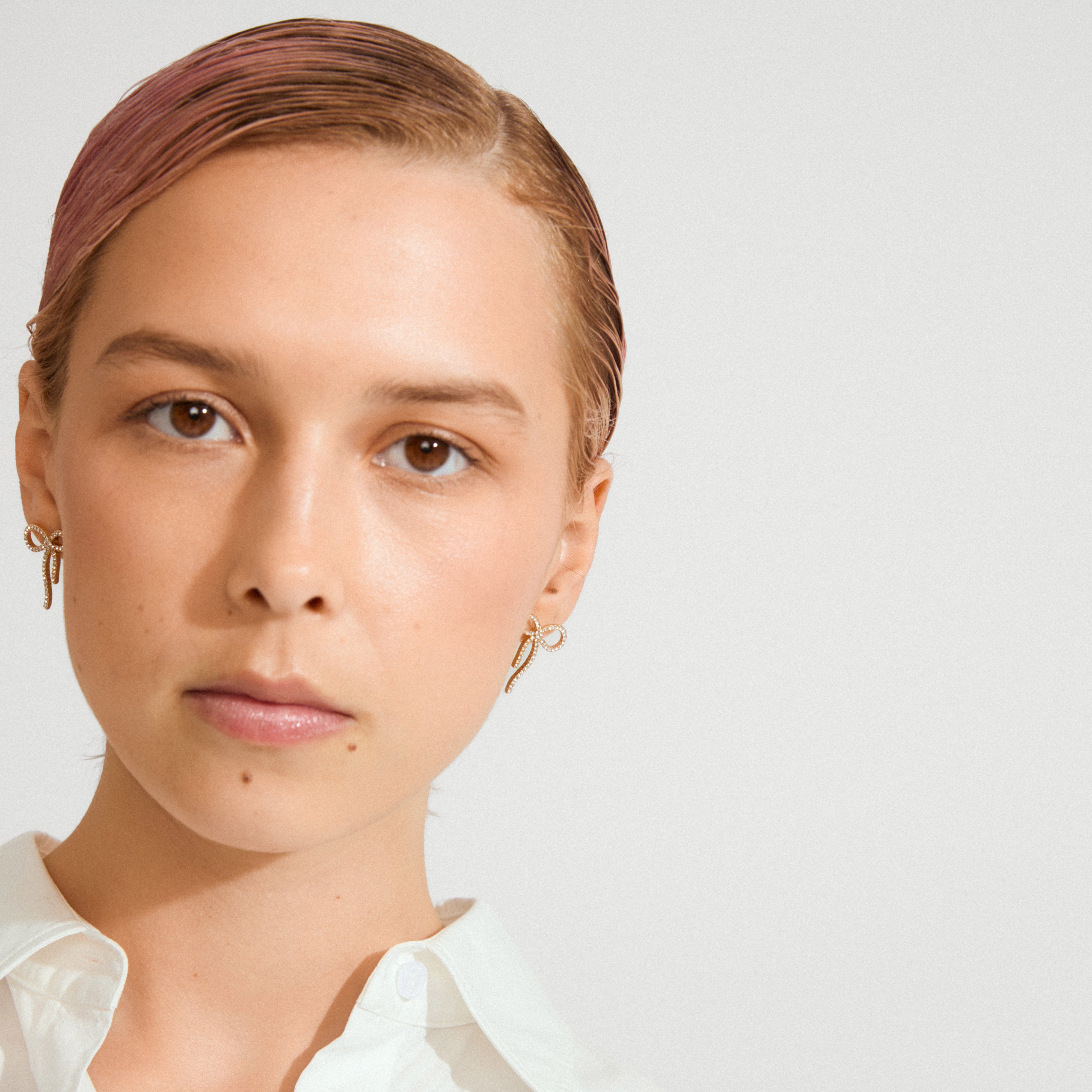 JOLANTA earrings gold-plated: Delicate bow-shaped earrings adorned with Preciosa crystals, perfect for elevating everyday outfits or adding sparkle to formal looks.