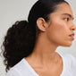 JOLINA recycled earrings in rose gold-plated design featuring intertwined halos with sparkling crystals, worn by a woman with a ponytail and visible ear.