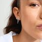 JOLANTA earrings silver-plated: Close-up of a woman's ear adorned with silver bow earrings featuring sparkling Preciosa crystals, showcasing trendy, eco-friendly Danish design.