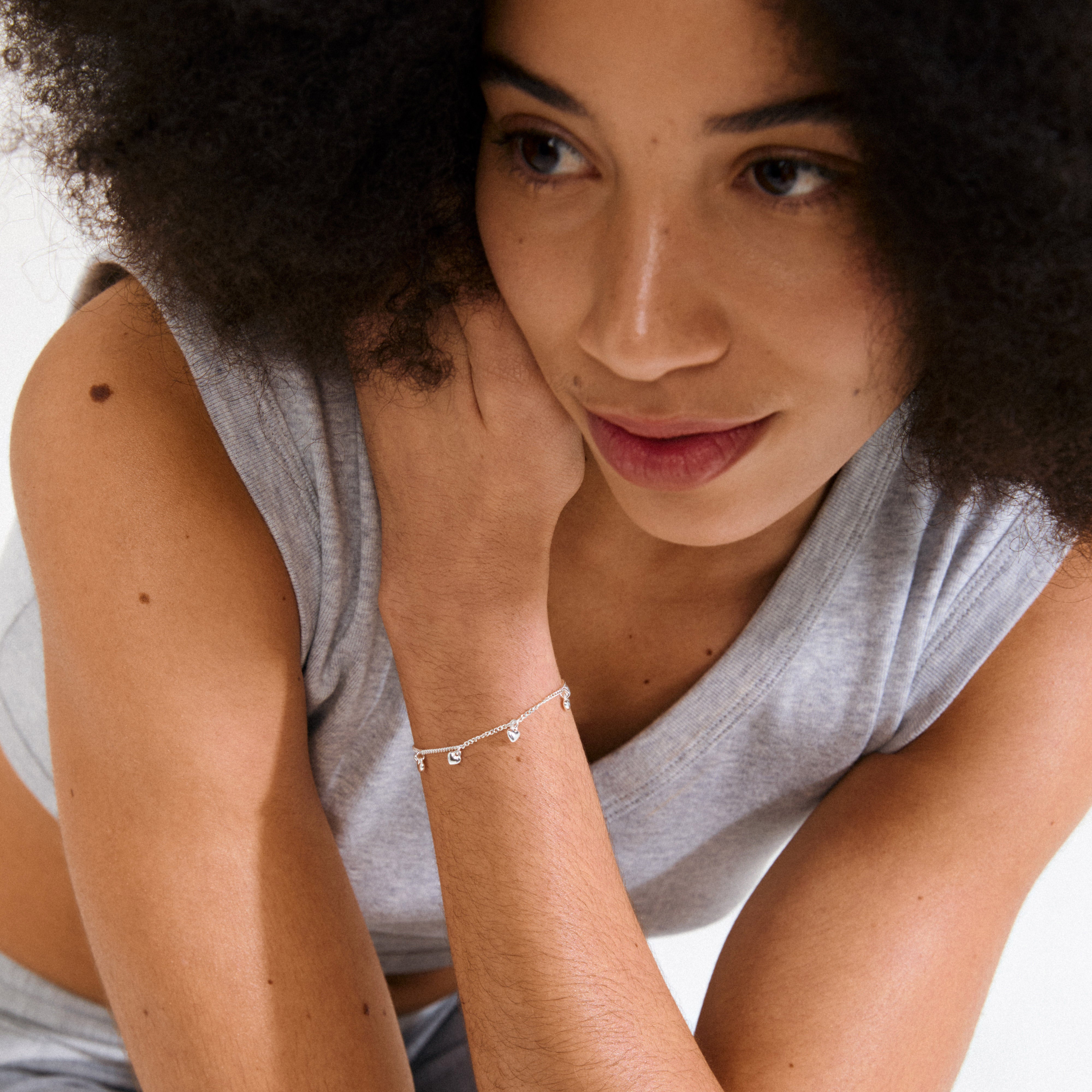 ALAIA bracelet silver-plated, featuring a slim curb chain with eight tiny heart pendants, offers a playful, romantic touch for everyday wear and special occasions.