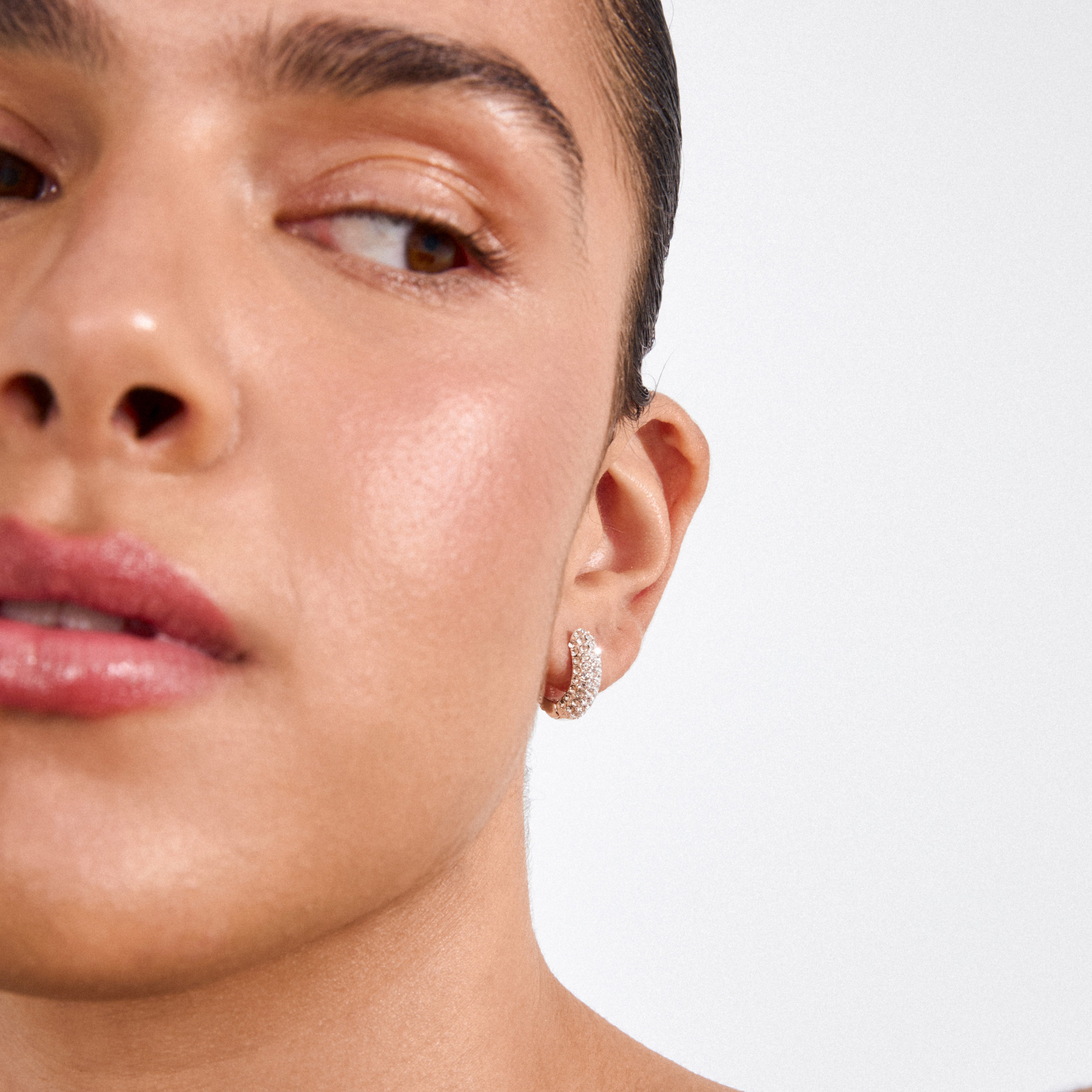 LONA chunky crystal huggie hoops, silver-plated, sparkle on a smooth ear, highlighting glam sophistication with Preciosa crystals, crafted from 98% recycled materials.