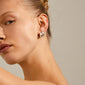 MINE chunky huggie hoops silver-plated earrings on a woman's ear, showcasing their shiny, chunky design, perfect for a classy and feminine look.