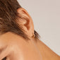 Close-up of an ear wearing EBNA small crystal hoops gold-plated, adorned with sparkling Preciosa crystals, showcasing their elegance and smart click lock design.