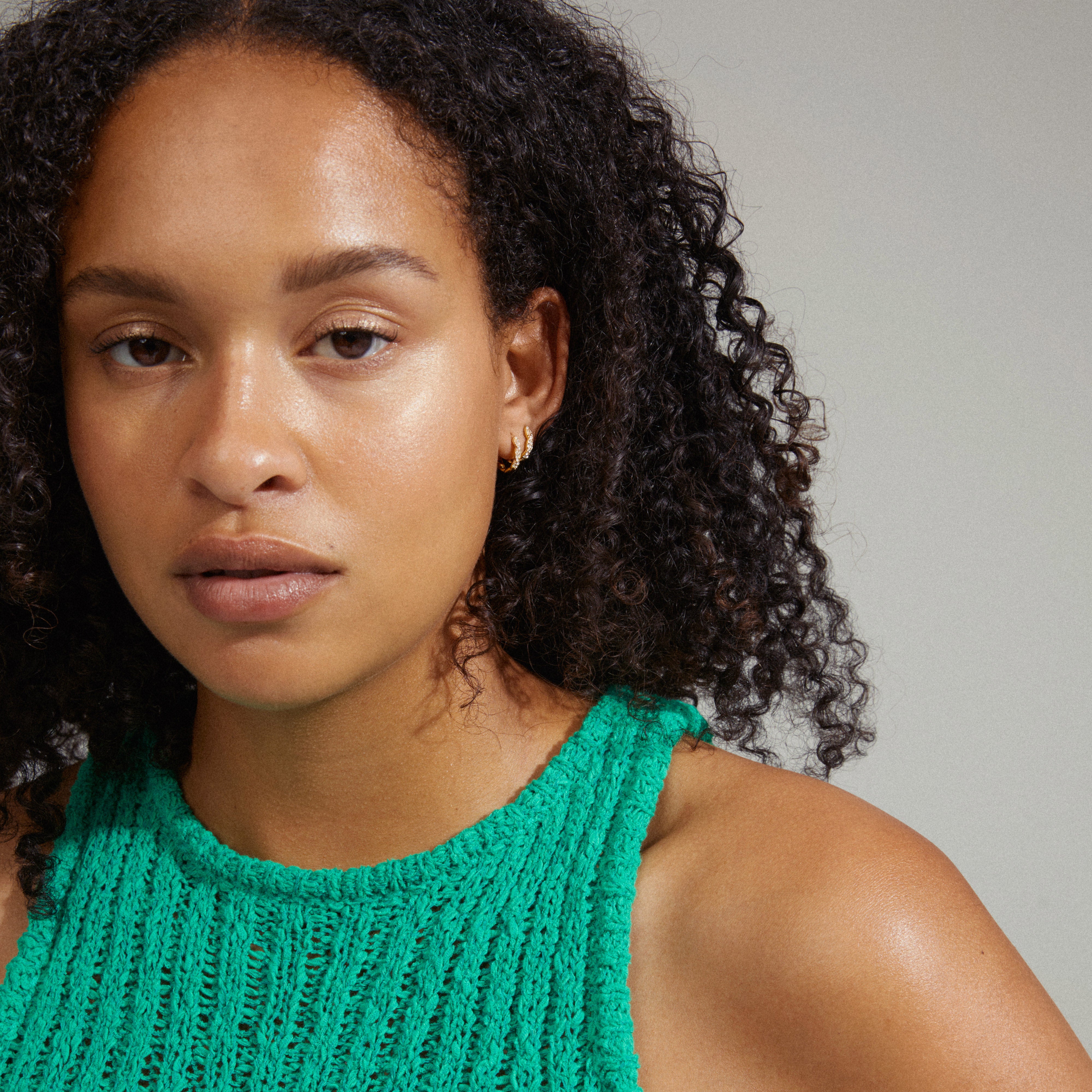 Woman wearing EZO twirled crystal hoops gold-plated, showcasing fine twisted details and shimmering Preciosa crystals, reflecting Pilgrim's timeless and trendy style.