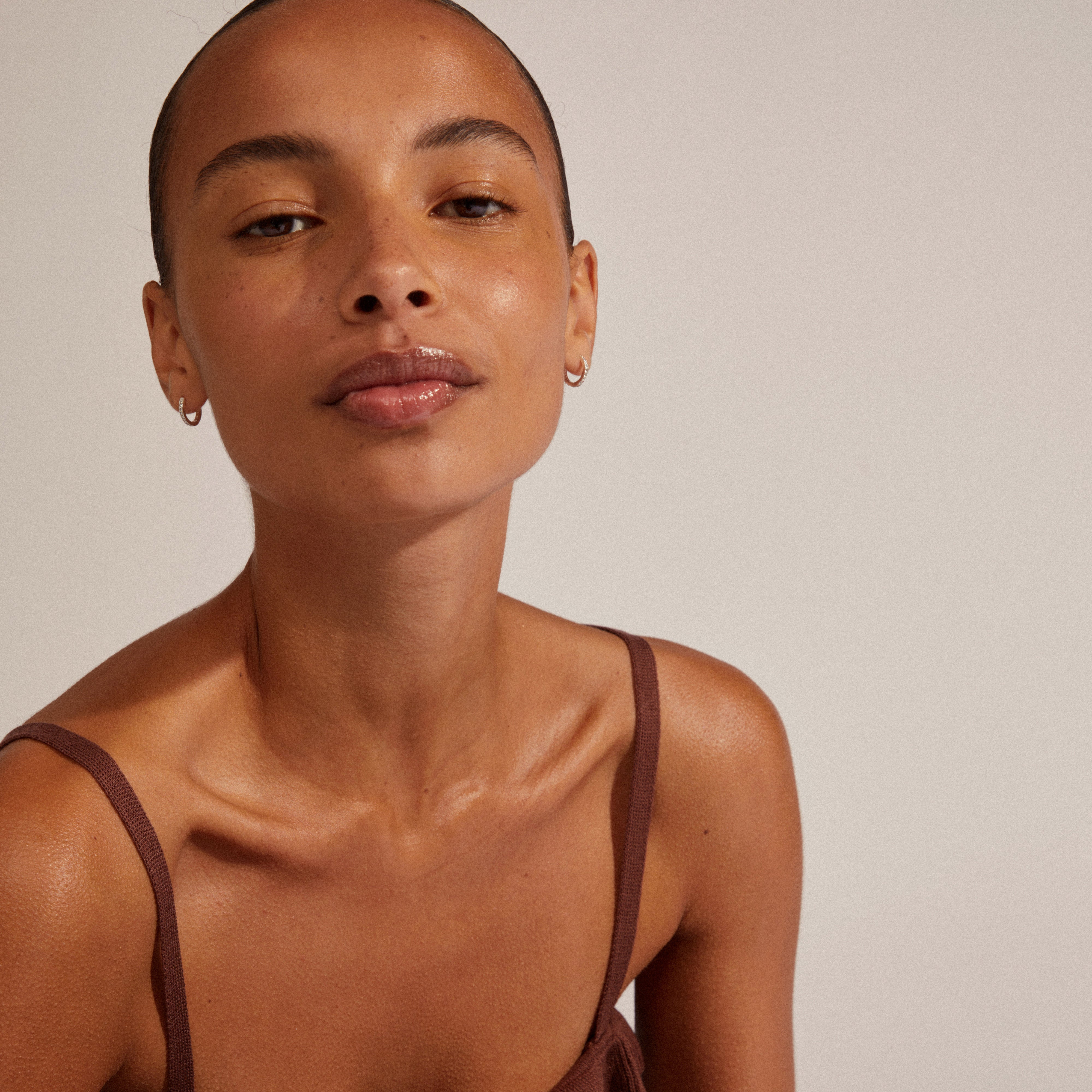 EBNA small crystal hoops silver-plated, worn by a woman, highlighting their elegance and ease with a smart click lock for a minimalist, classy look.