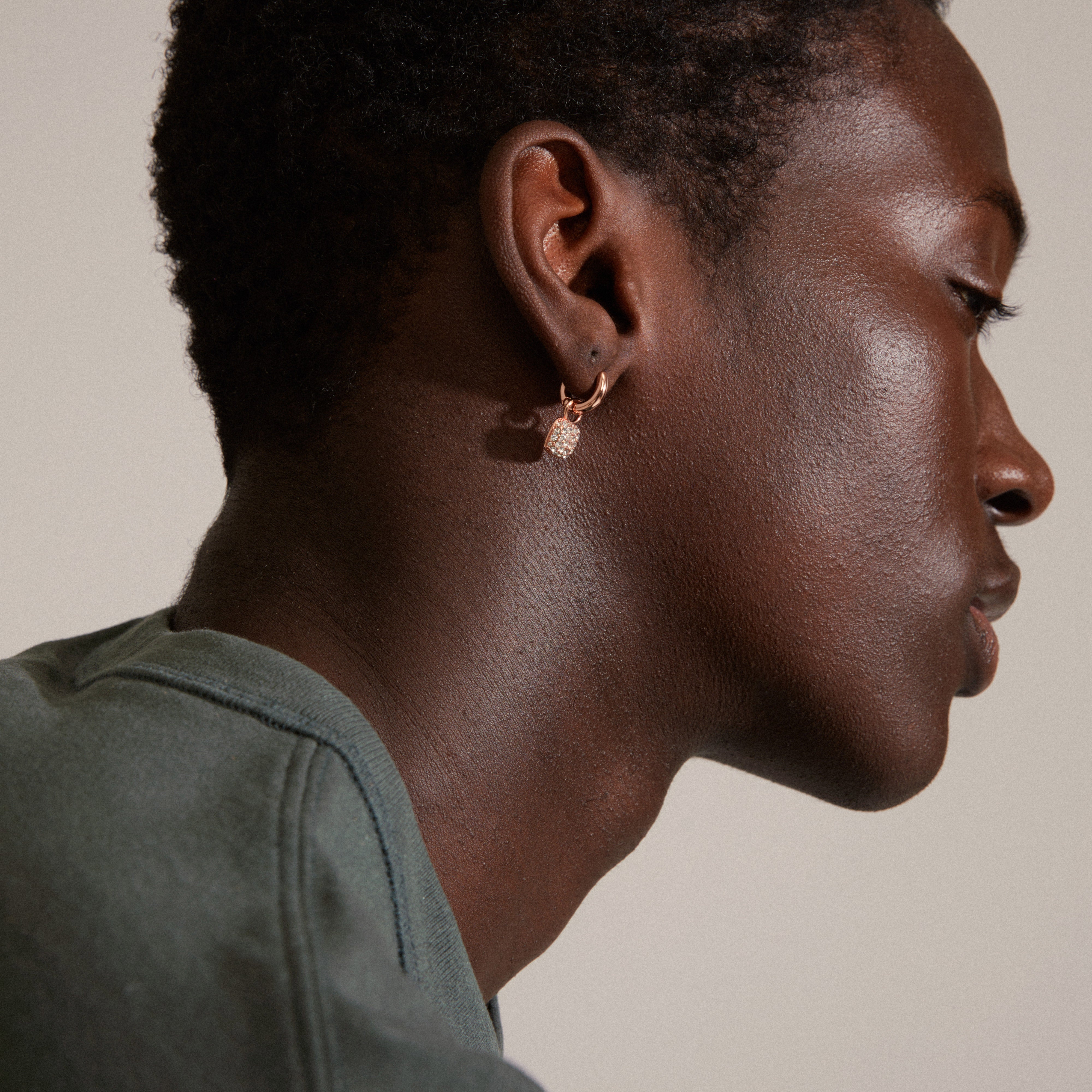 CINDY crystal hoop earrings rosegold-plated, featuring squared pendants with sparkling Preciosa crystals, worn by a man with short hair and a gold earring.