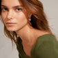 CINDY crystal hoop earrings in silver-plated design with sparkling Preciosa crystals, featuring simple huggie hoops and detachable squared pendants, displayed by a woman.